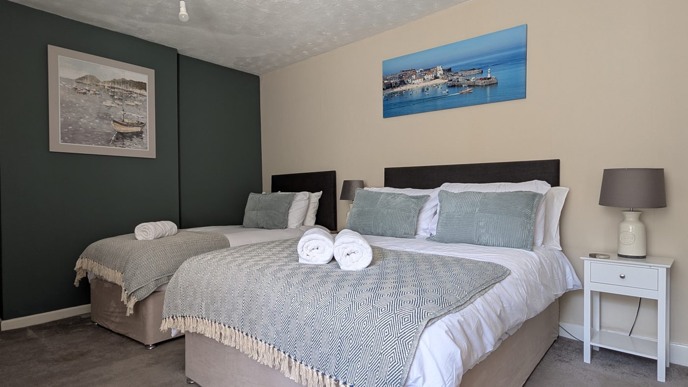 Room 5, the triple — a double and a single bed beneath a St Ives canvas